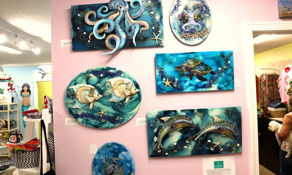 Ceramic sea-life wall plaques by a local artist on a pink gallery wall